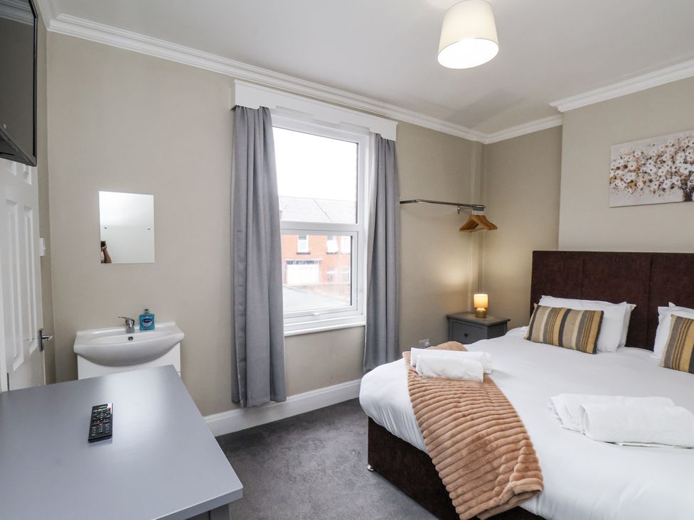 A bedroom with a bed and sink at Tennyson House in Scarborough