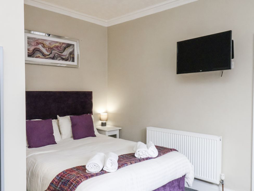 A bedroom with a bed and television at Tennyson House, Scarborough