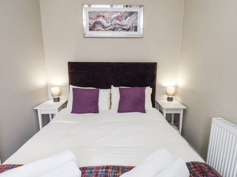 A bedroom with a bed and bedside tables at Tennyson House in Scarborough