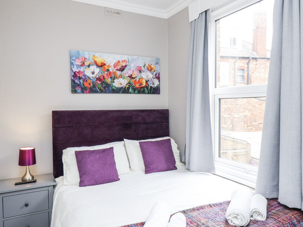 A bedroom with a bed, pillows, and a window at Tennyson House in Scarborough