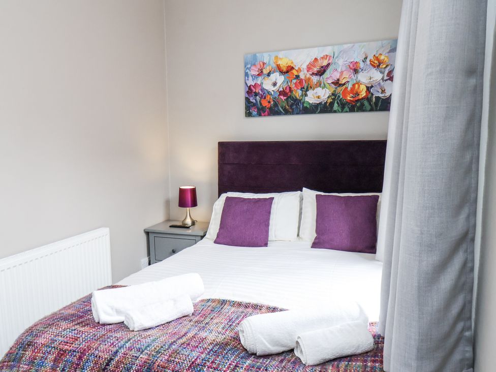 A bedroom with a bed and wall art at Tennyson House in Scarborough