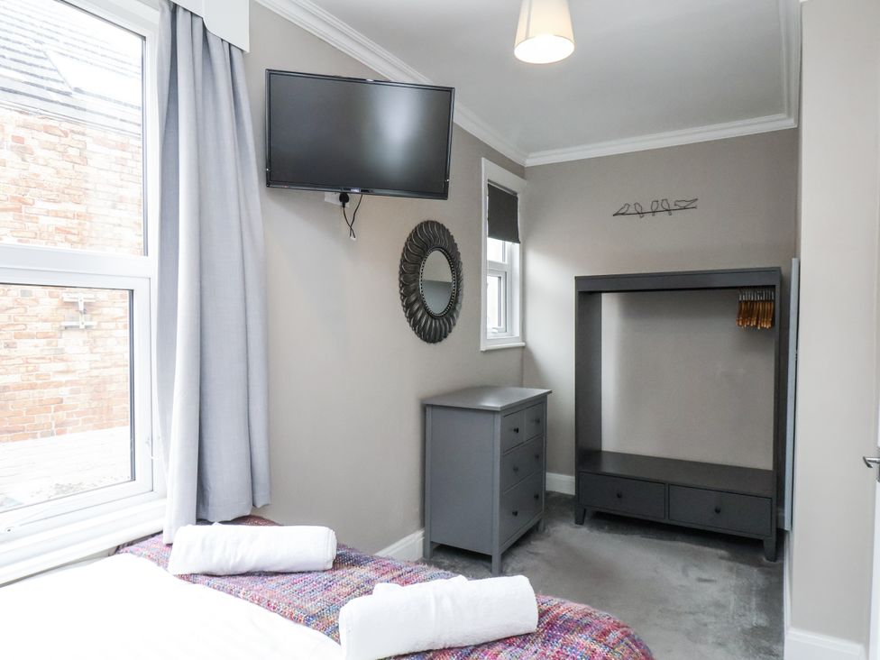 A bedroom with a bed and a television at Tennyson House in Scarborough