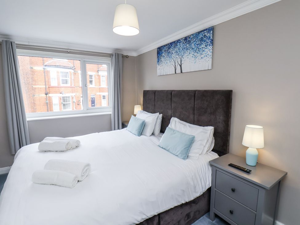 A bedroom with a bed and bedside lamp at Tennyson House in Scarborough