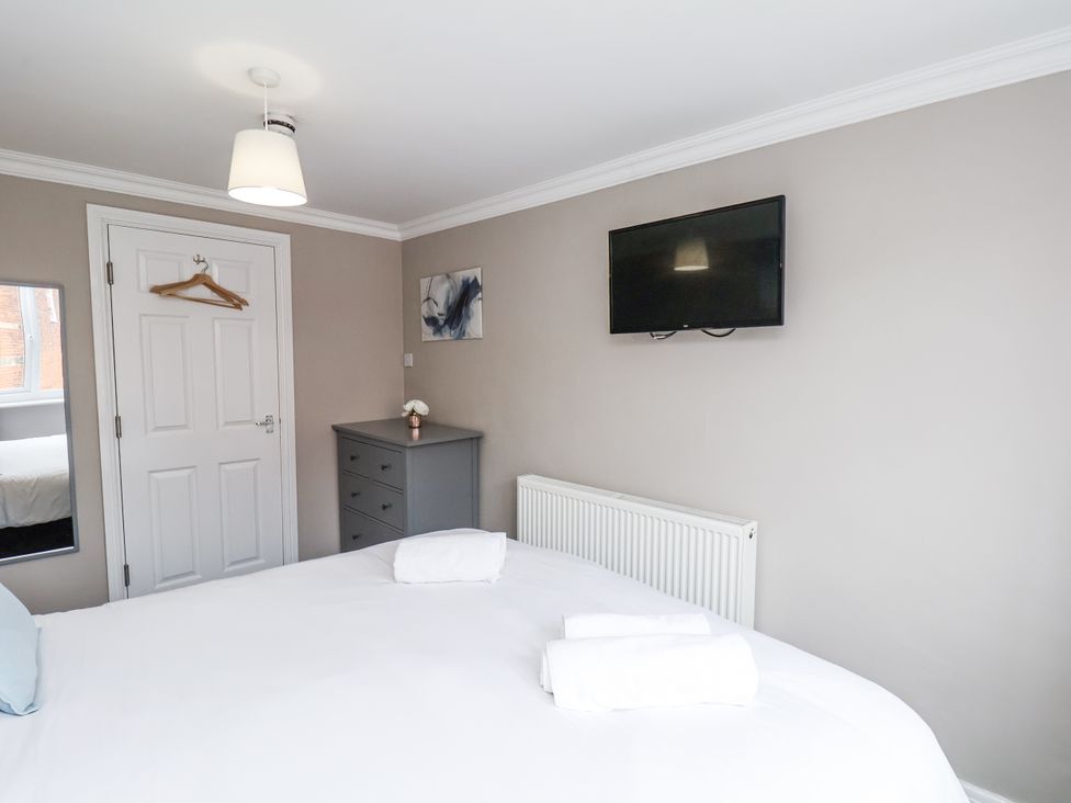 A bedroom with a bed and television at Tennyson House in Scarborough
