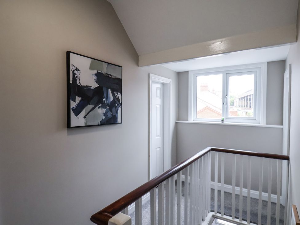 A hallway with a staircase and a painting at Tennyson House in Scarborough