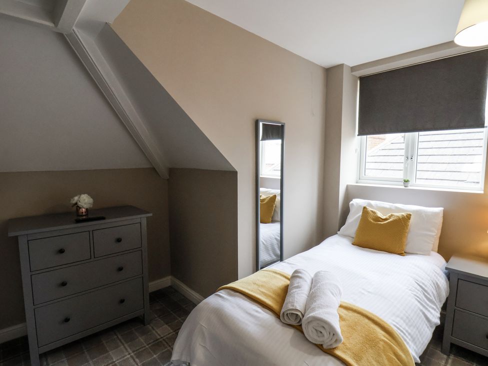 A bedroom with a bed and dresser at Tennyson House in Scarborough