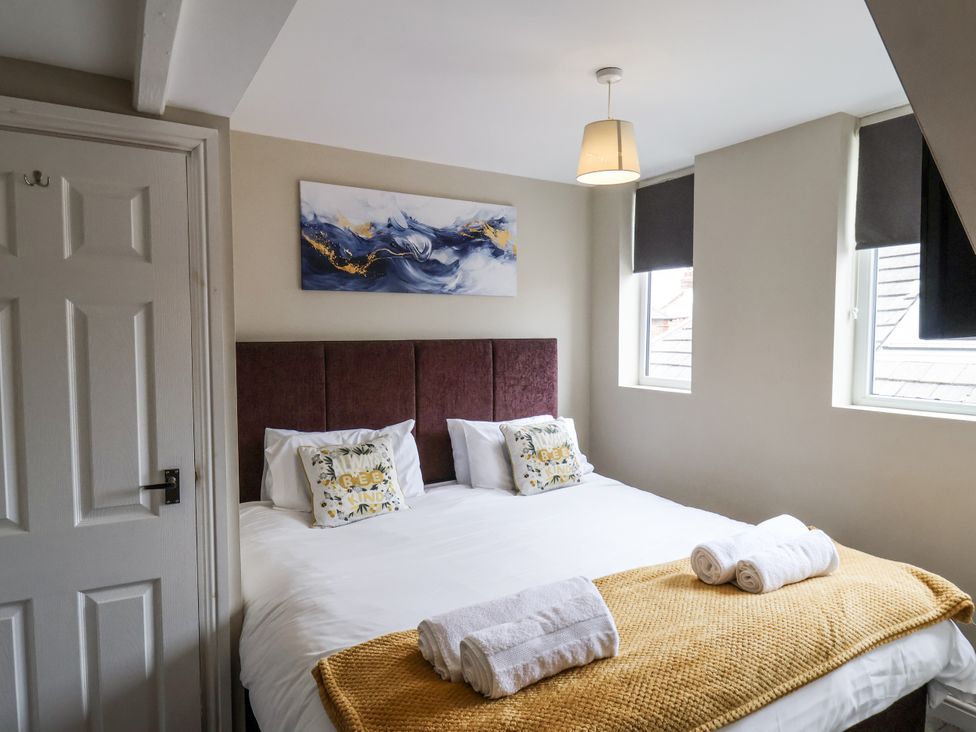 A bedroom with a bed and wall art at Tennyson House in Scarborough