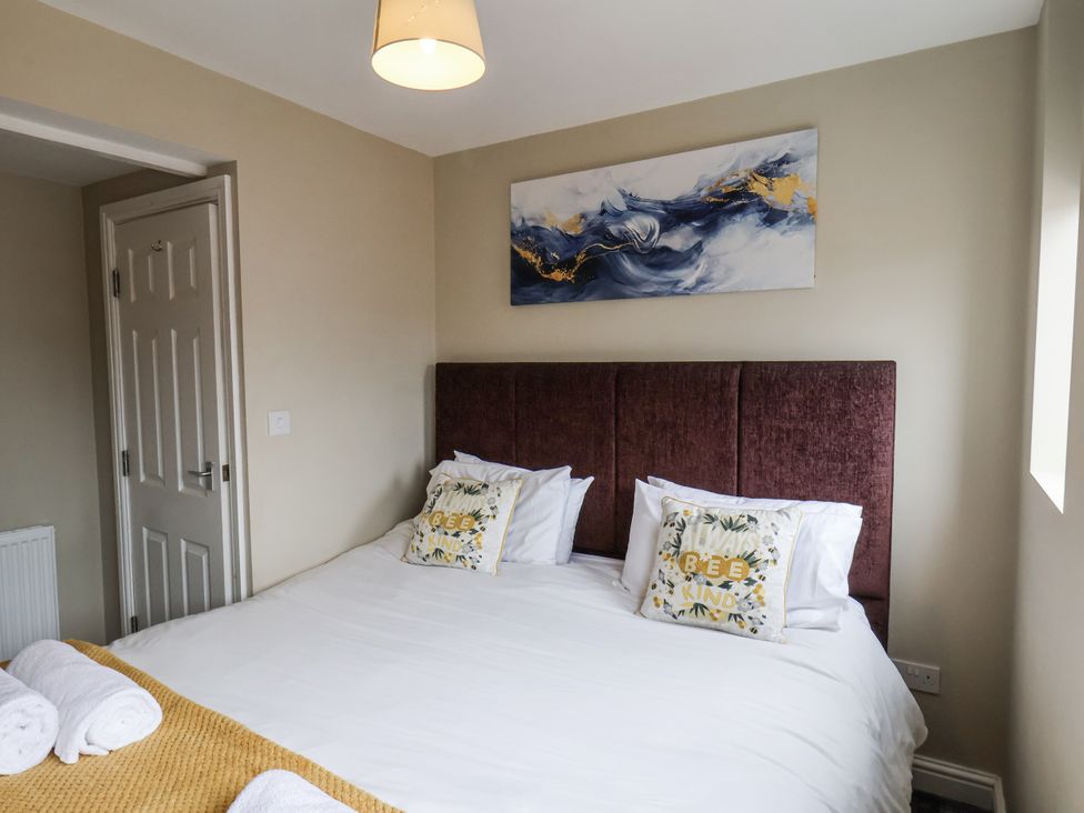 A bedroom with a bed and wall art at Tennyson House in Scarborough