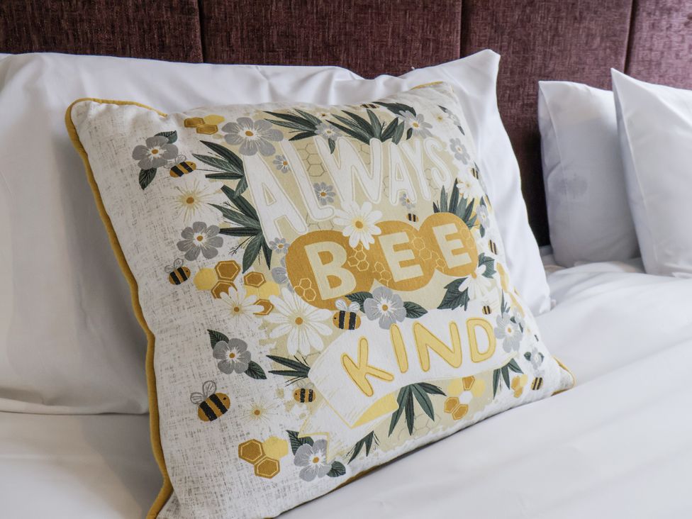 A decorative pillow with a design on a bed at Tennyson House in Scarborough