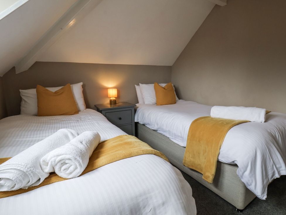 A bedroom with two beds and a lamp at Tennyson House in Scarborough
