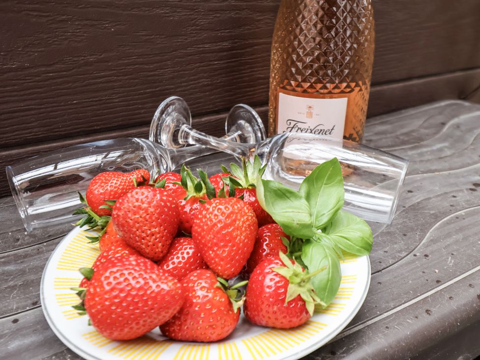 A plate of strawberries with wine glasses and a bottle at Tennyson House in Scarborough