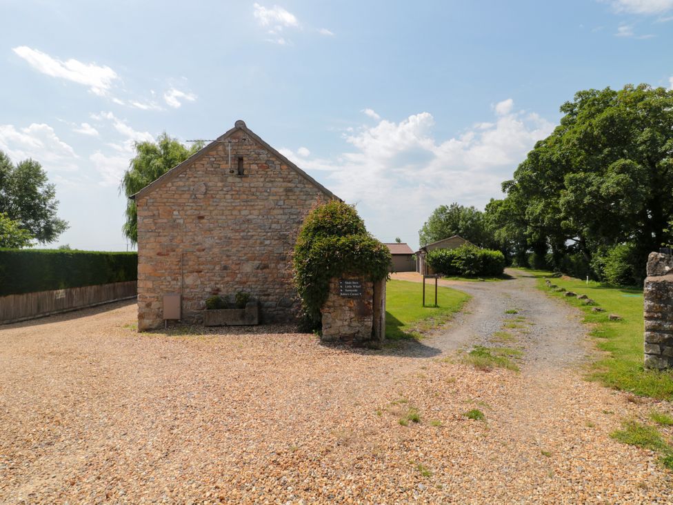 An outdoor view of a stone building and pathway at Little Wharf in Bleadon
