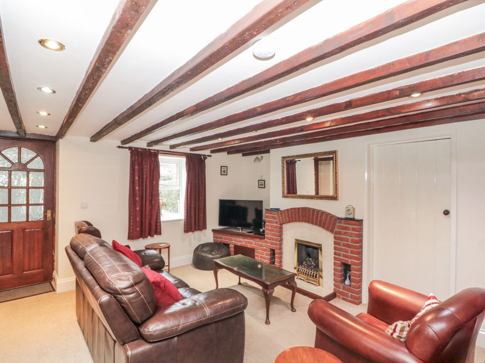 A living room with a TV and fireplace at Dove Cottage in Sleights