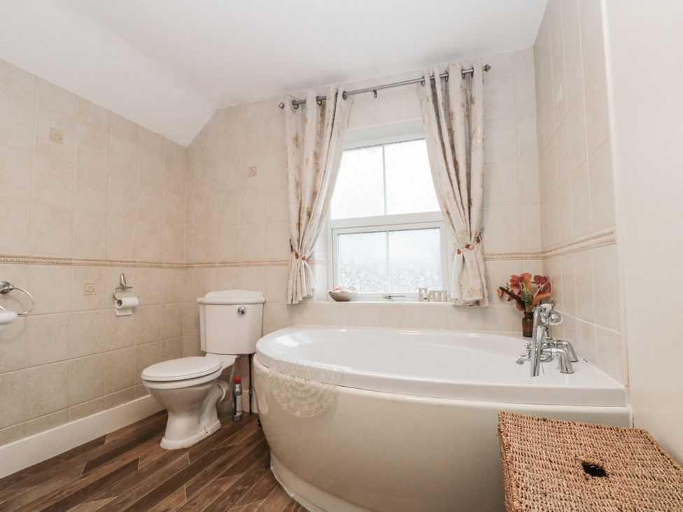 A bathroom with a bathtub and toilet at Dove Cottage in Sleights