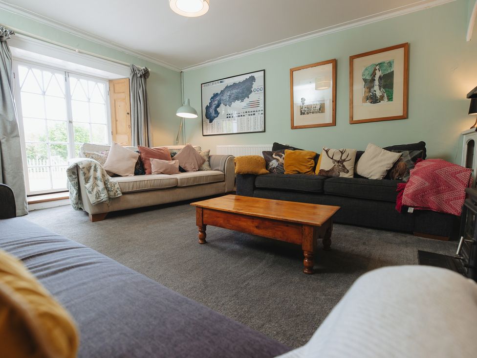 A living room with sofas and a coffee table at Cwmalis Hall in Llangollen