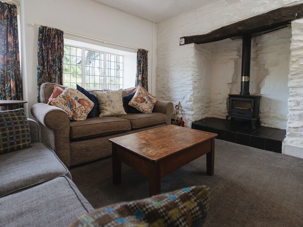 A living room with a sofa and wooden coffee table at Cwmalis Hall in Llangollen