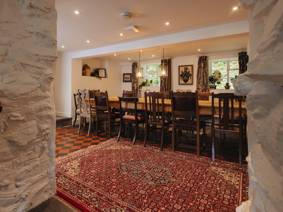 A dining room with a long table and chairs at Cwmalis Hall Llangollen