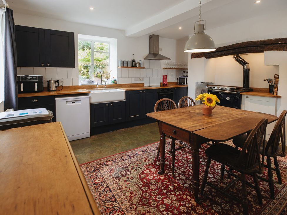 A kitchen with a table and chairs at Cwmalis Hall in Llangollen