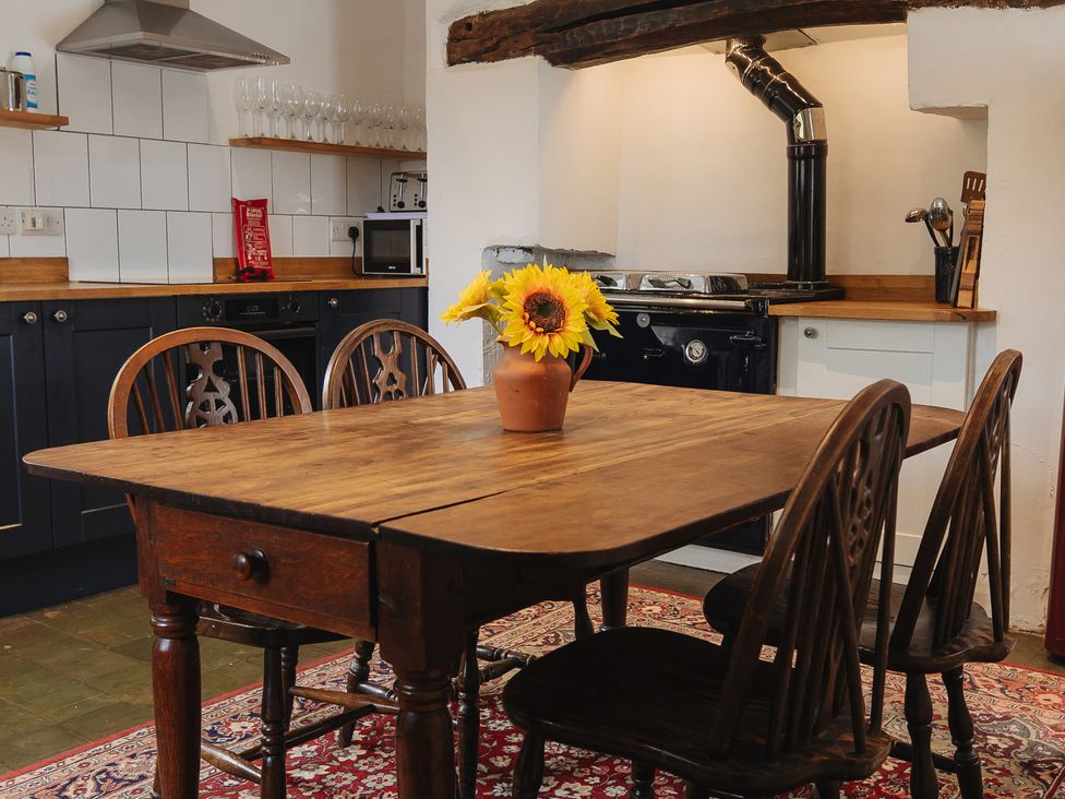 A kitchen with a dining table and chairs at Cwmalis Hall Llangollen