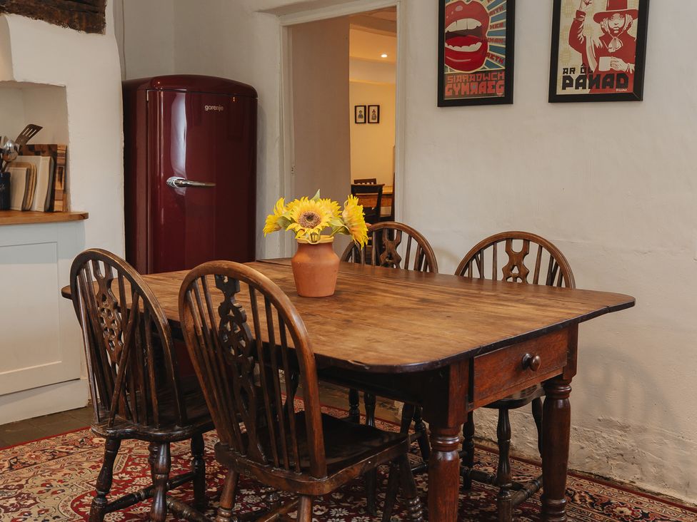 A dining room with a wooden table and chairs at Cwmalis Hall in Llangollen