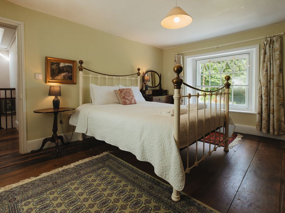 A bedroom with a bed and lamp at Cwmalis Hall Llangollen