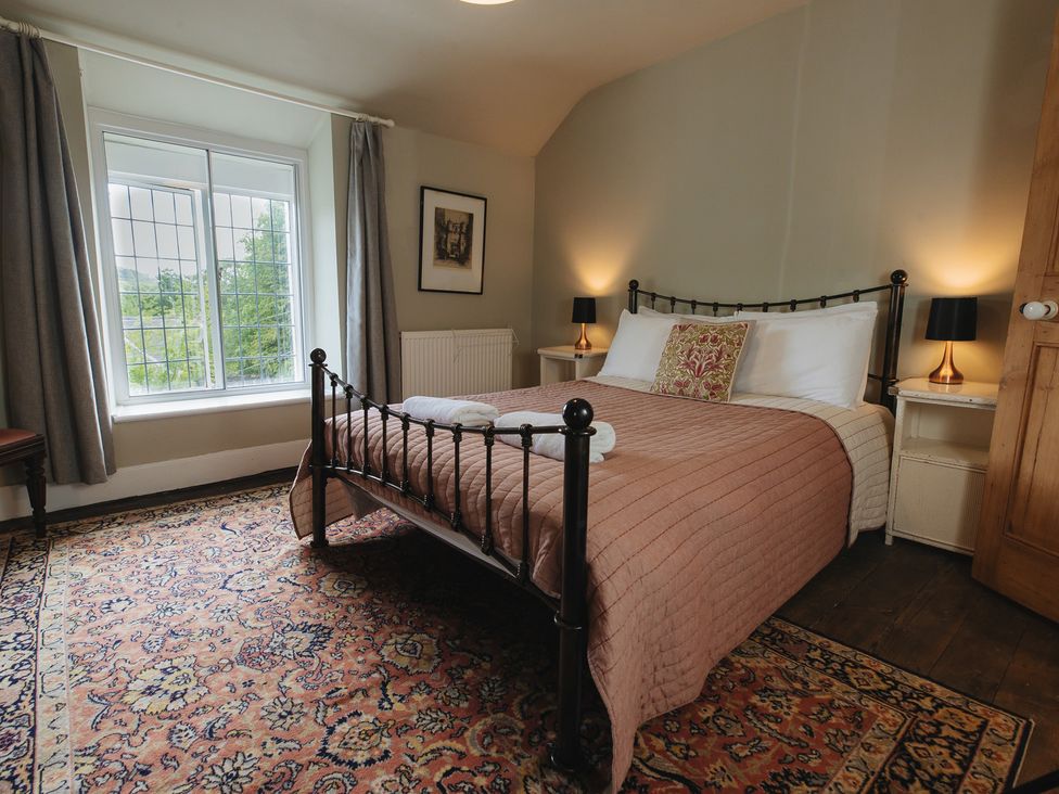 A bedroom with a bed and nightstands at Cwmalis Hall in Llangollen