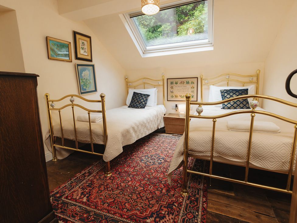 A bedroom with two beds and window at Cwmalis Hall in Llangollen
