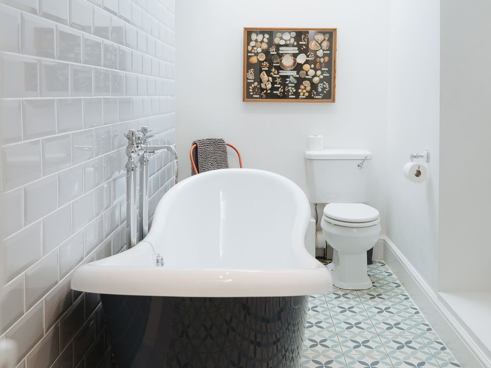 A bathroom with a bathtub and toilet at Cwmalis Hall in Llangollen