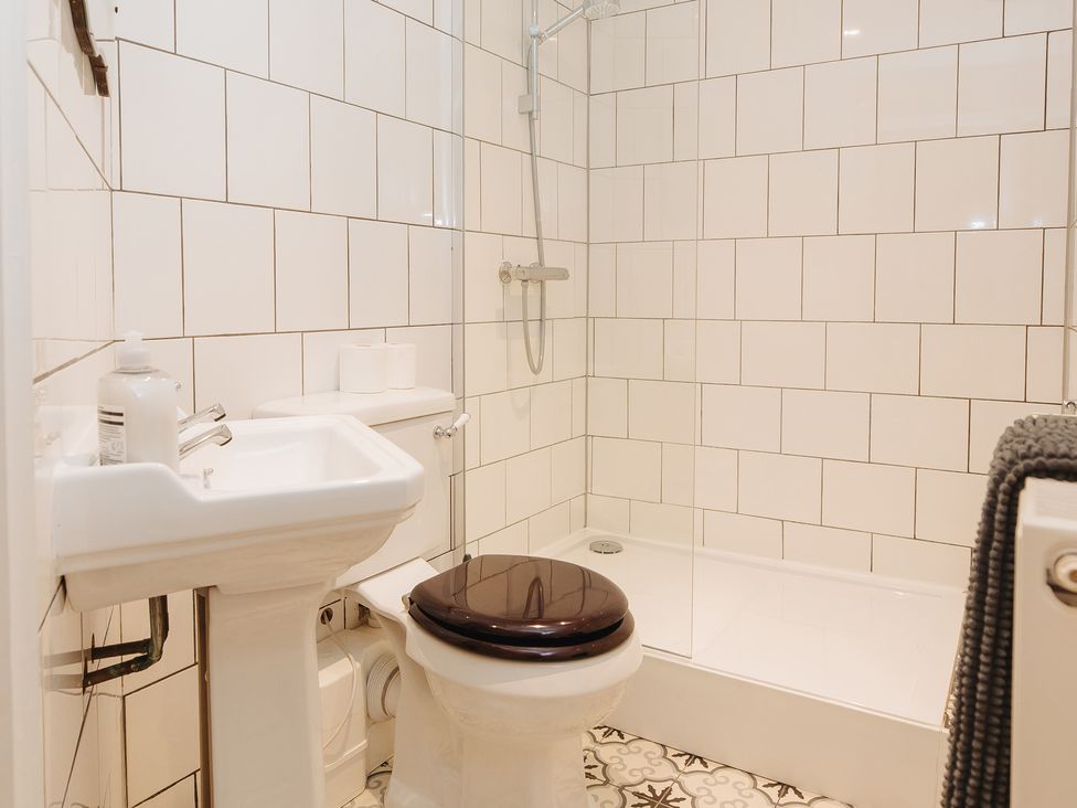 A bathroom with a shower, sink, and toilet at Cwmalis Hall Llangollen