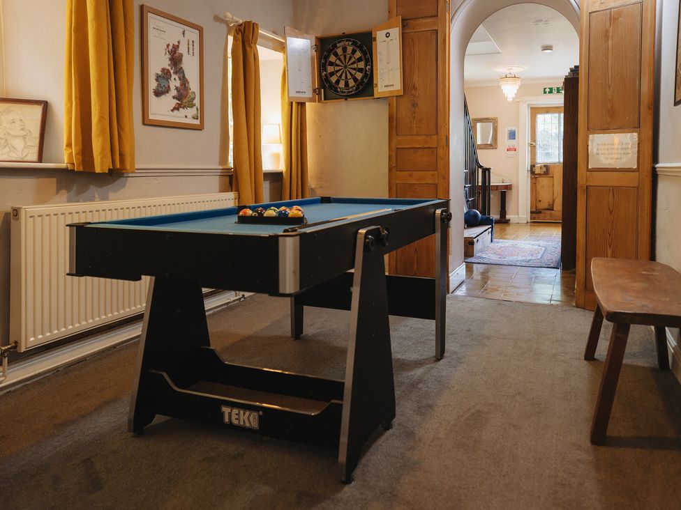 A game room with a pool table and darts board at Cwmalis Hall in Llangollen
