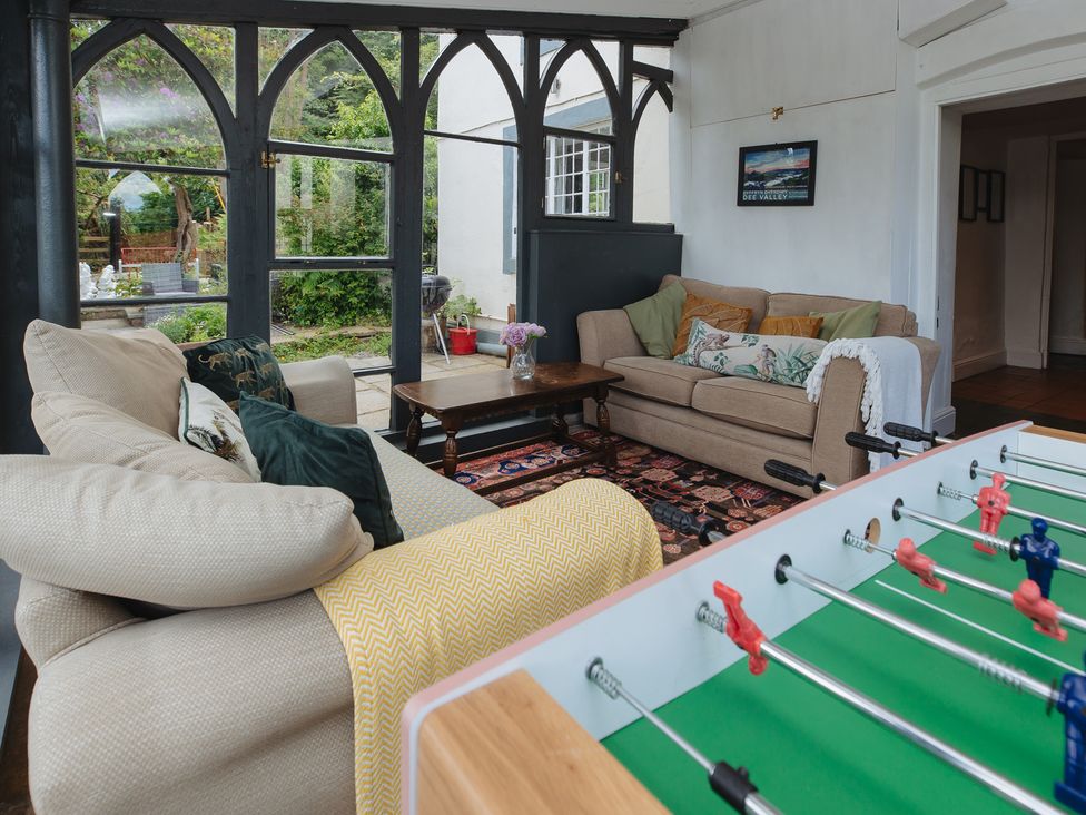 A snug room with a foosball table and sofas at Cwmalis Hall in Llangollen