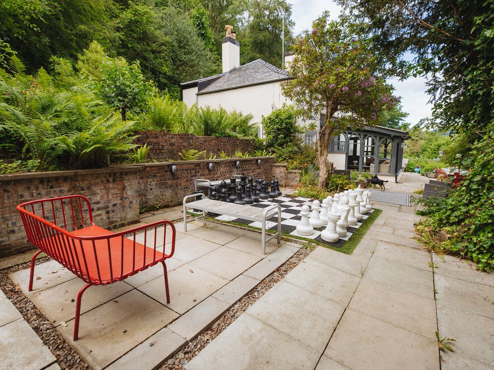 A garden with a large chess set and seating area at Cwmalis Hall in Llangollen