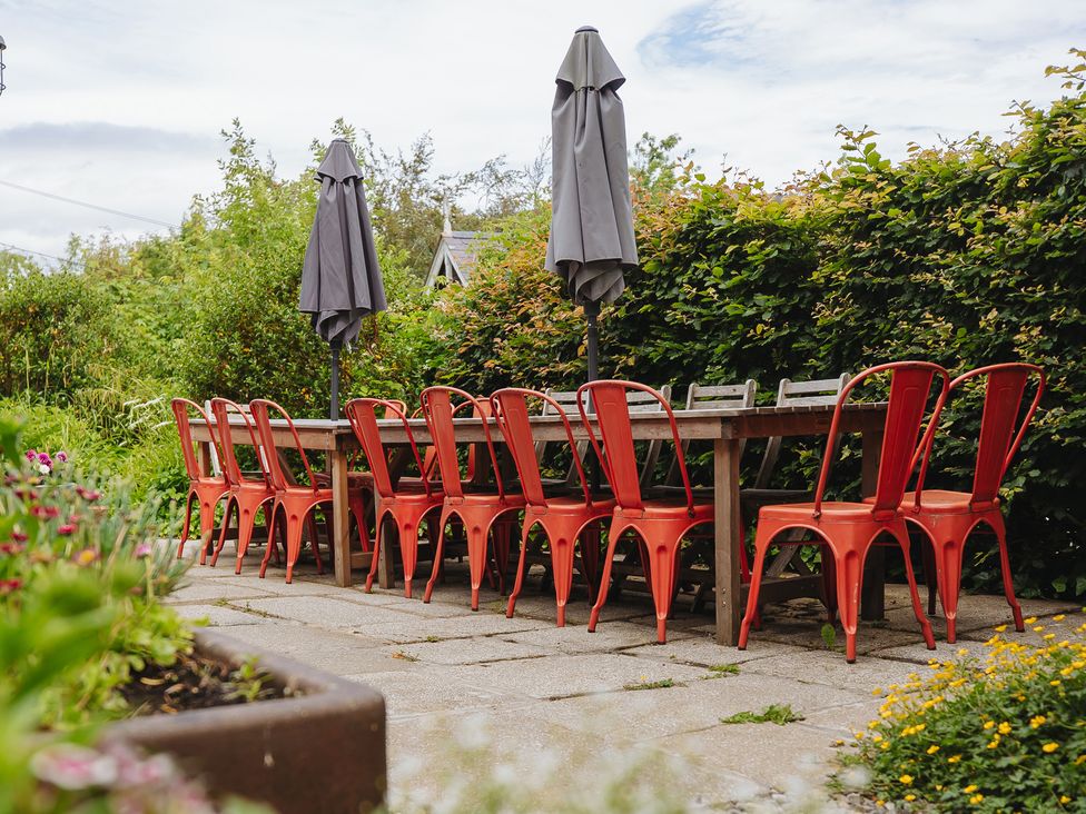 An outdoor dining area with a table and chairs at Cwmalis Hall in Llangollen