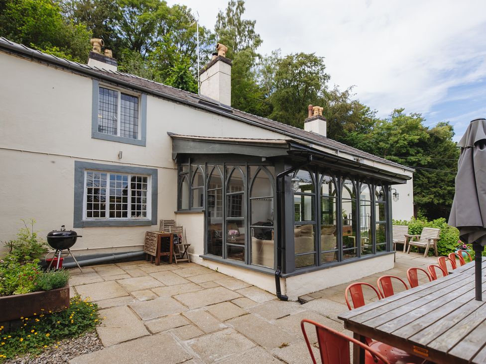 A conservatory attached to a house with a table and chairs at Cwmalis Hall Llangollen