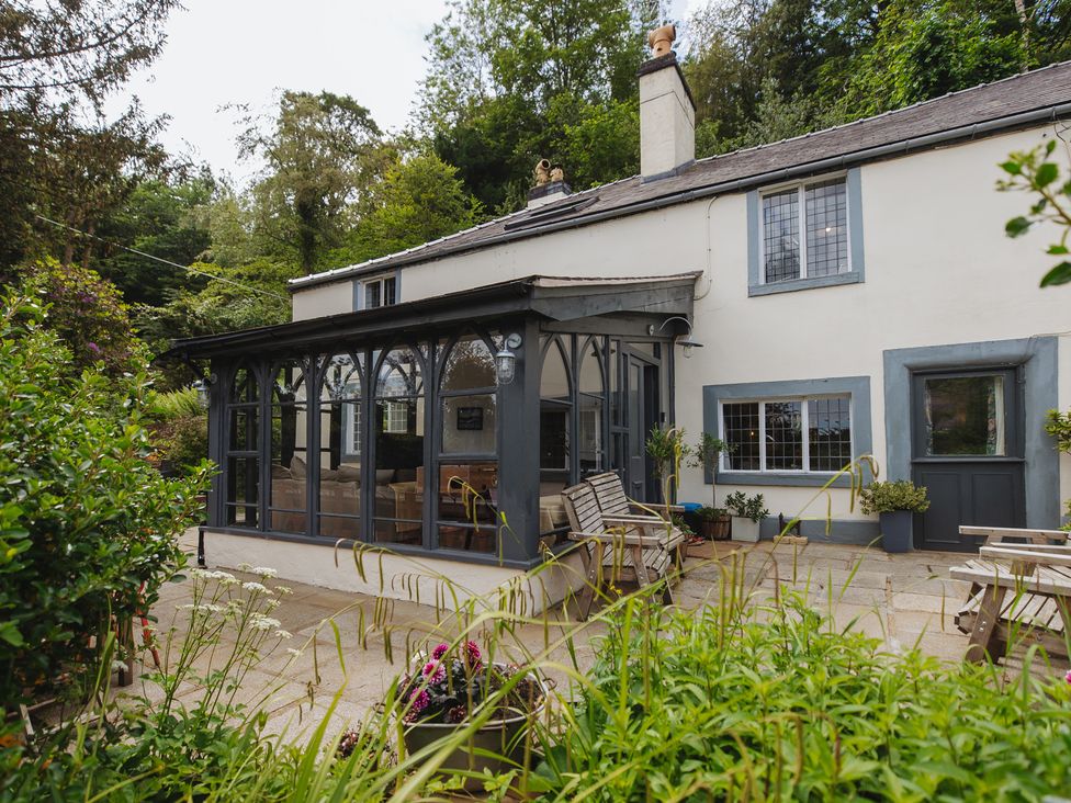 A cottage with a porch and outdoor seating at Cwmalis Hall Llangollen