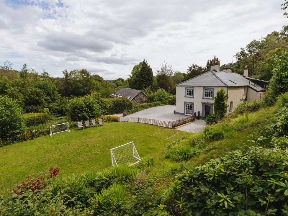 A house with lawn and chairs at Cwmalis Hall in Llangollen