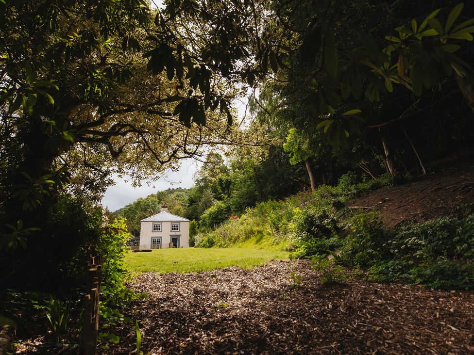 A house in a garden surrounded by trees at Cwmalis Hall Llangollen