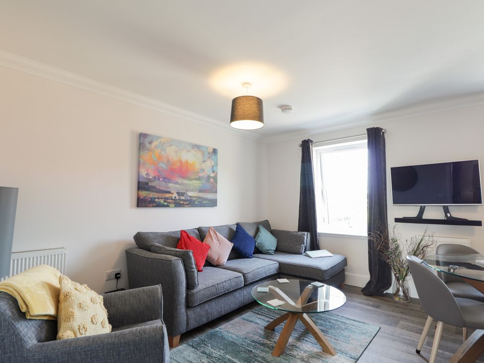 A living room with a sofa and TV at The Nook in Culloden