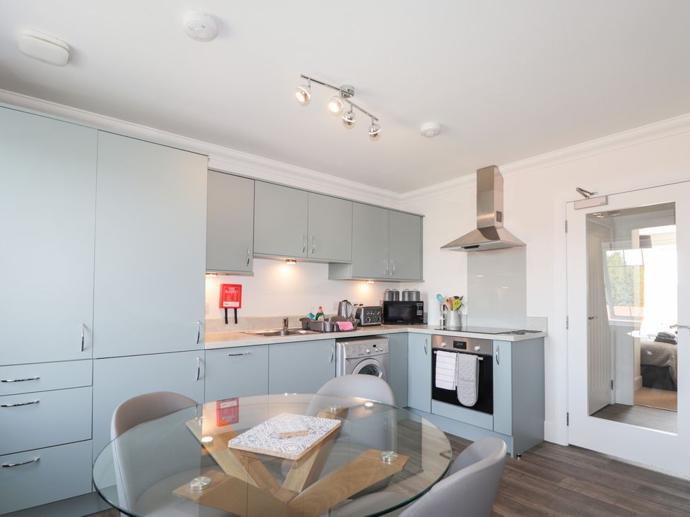 A kitchen with appliances and a dining table at The Nook in Culloden