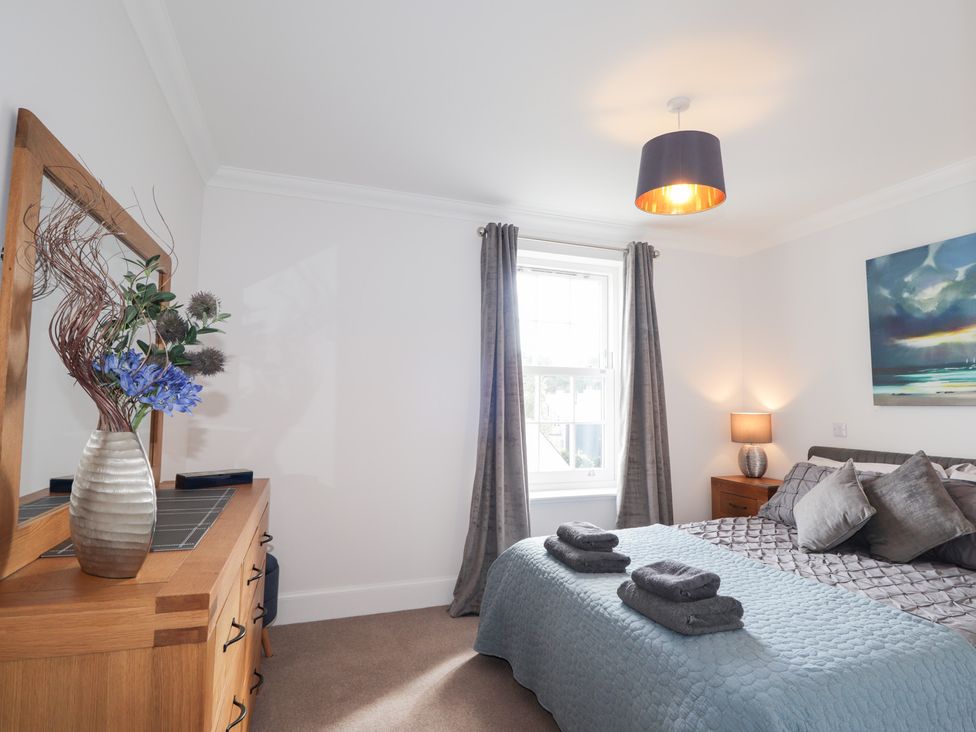 A bedroom with a bed, dresser and window at The Nook in Culloden