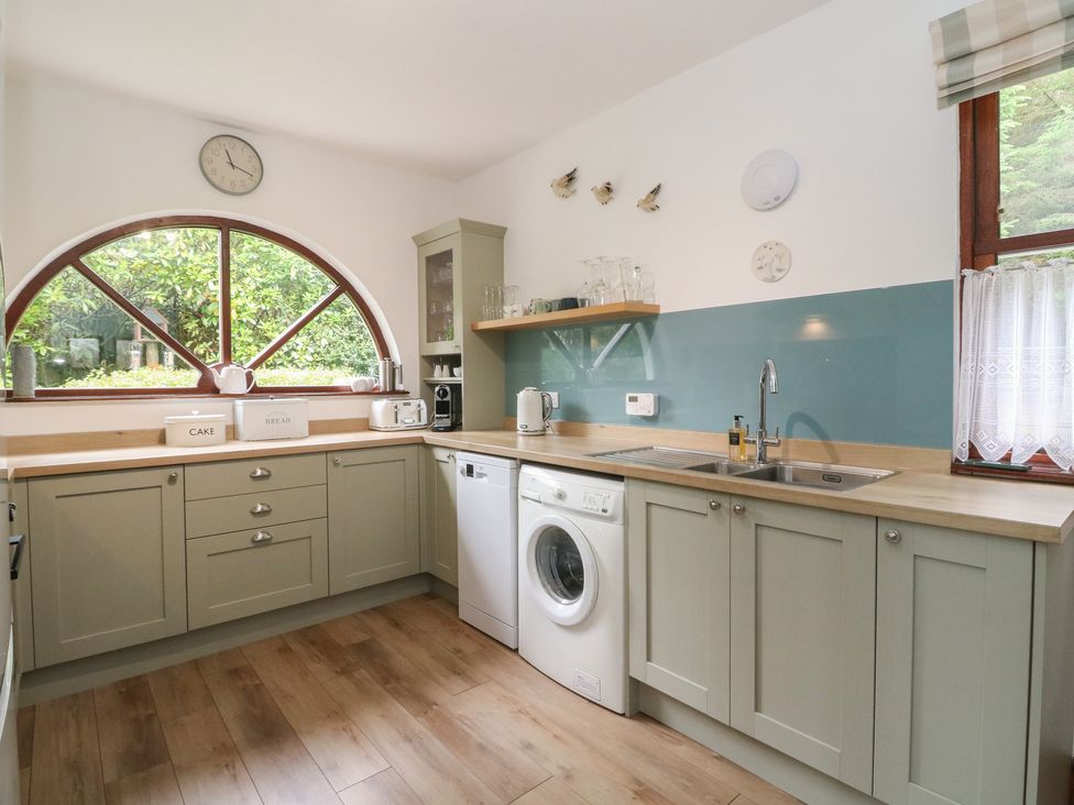 A kitchen with a sink and washing machine at Clearwater House in Roshven near Glenuig