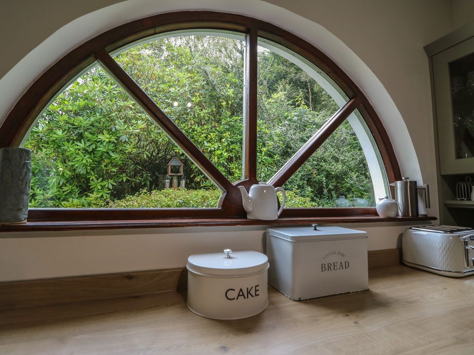 A kitchen with a window and storage containers at Clearwater House in Roshven near Glenuig