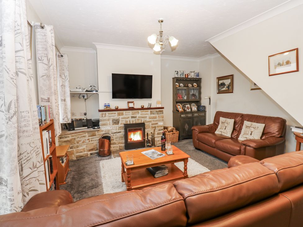 A living room with a sofa and television at Kelda Garthr (Tranquil Garden) Middleham