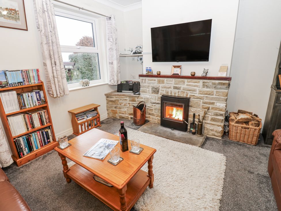 A living room with a fireplace and television at Kelda Garthr (Tranquil Garden) Middleham