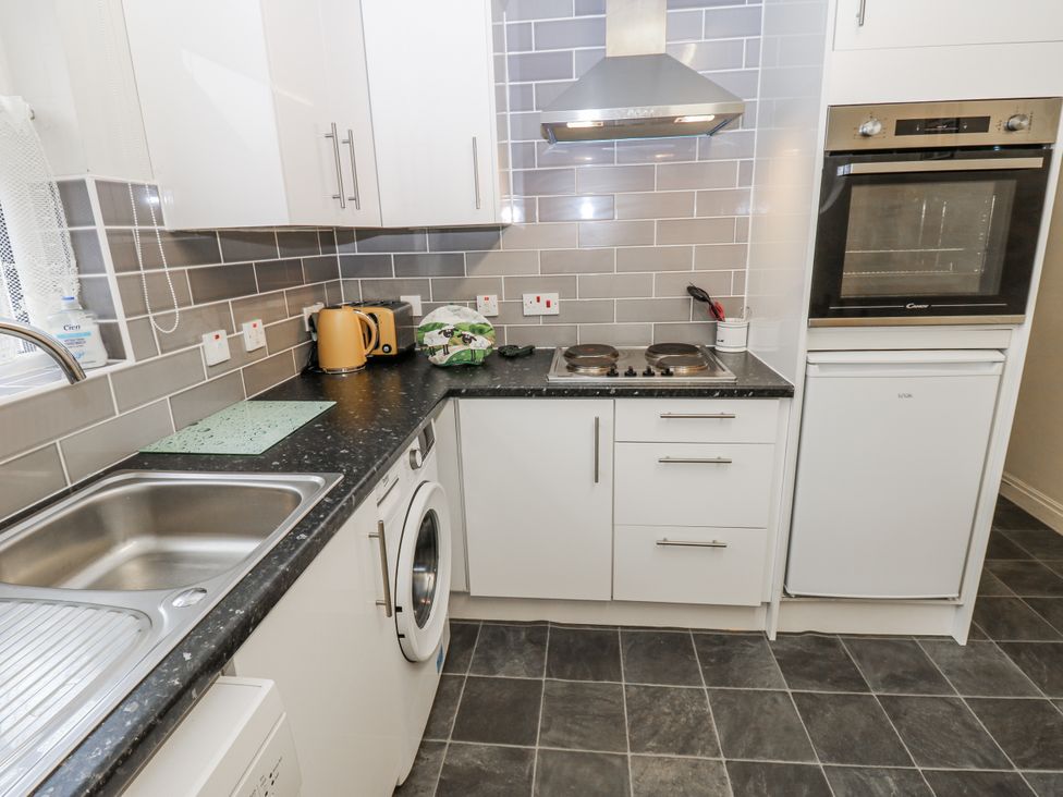 A kitchen with sink, washing machine, and oven at Kelda Garthr (Tranquil Garden) Middleham