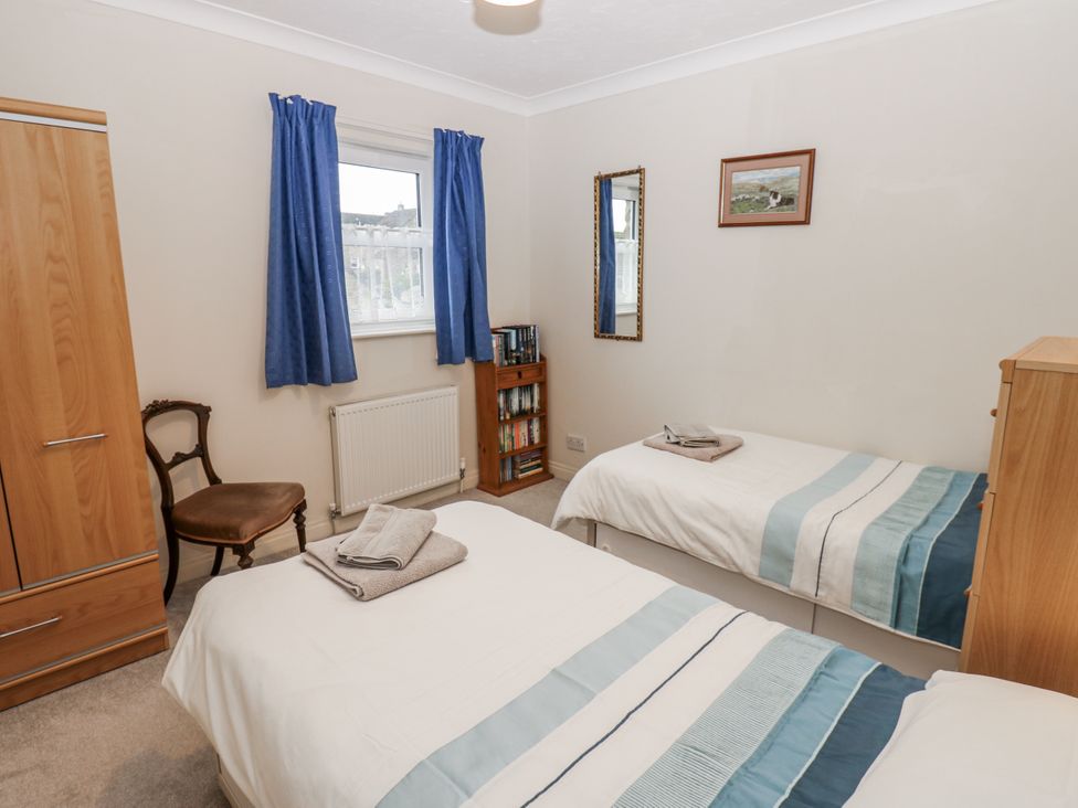 A bedroom with two single beds and a wardrobe at Kelda Garthr (Tranquil Garden) Middleham