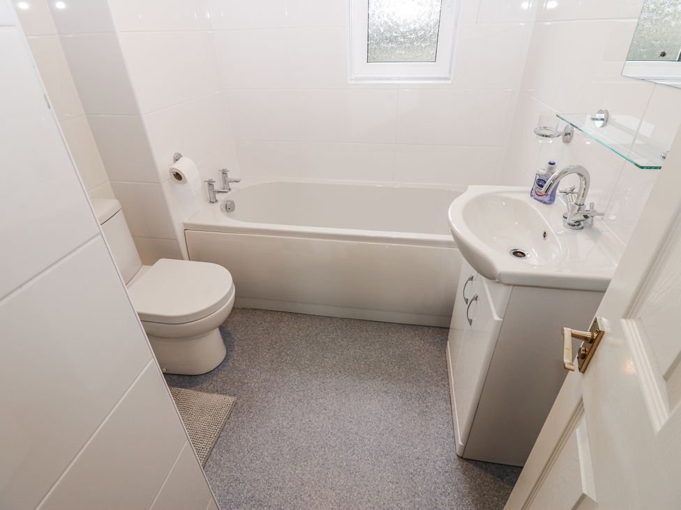 A bathroom with a bathtub, toilet, and sink at Kelda Garthr (Tranquil Garden) in Middleham