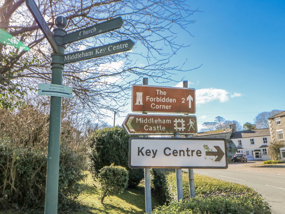 A signpost indicating directions in Middleham with information about local attractions