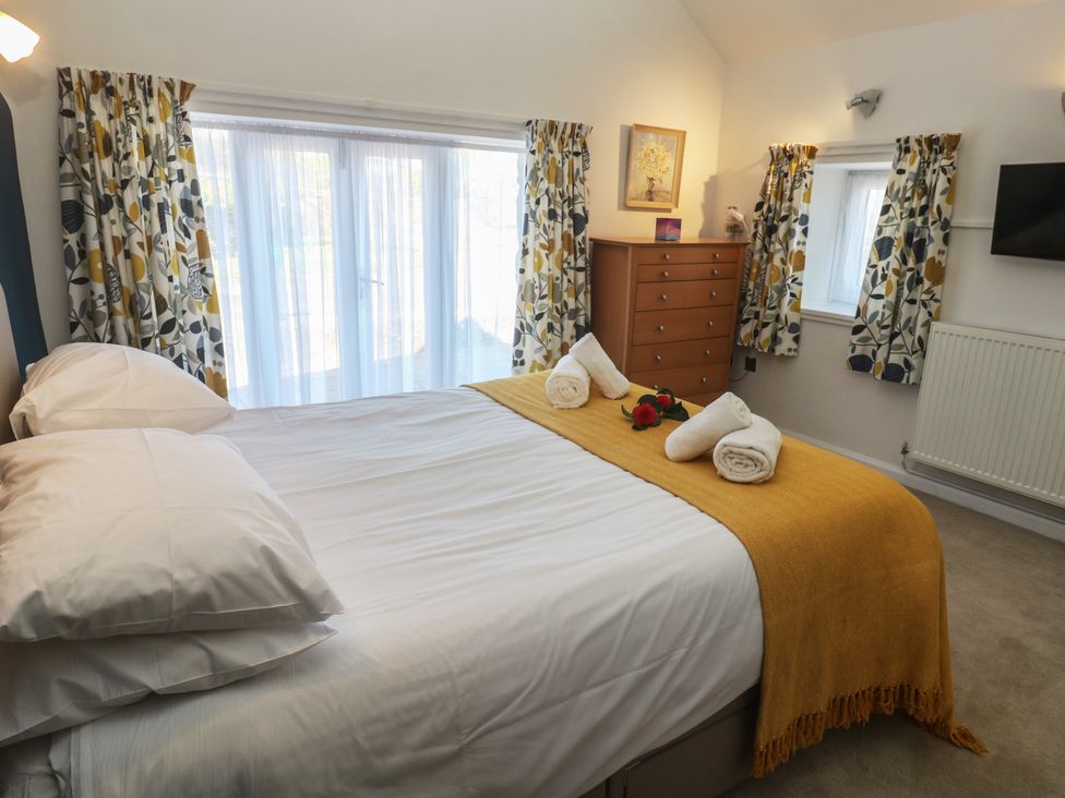A bedroom with a bed and a dresser at Meadowside in Mousehole