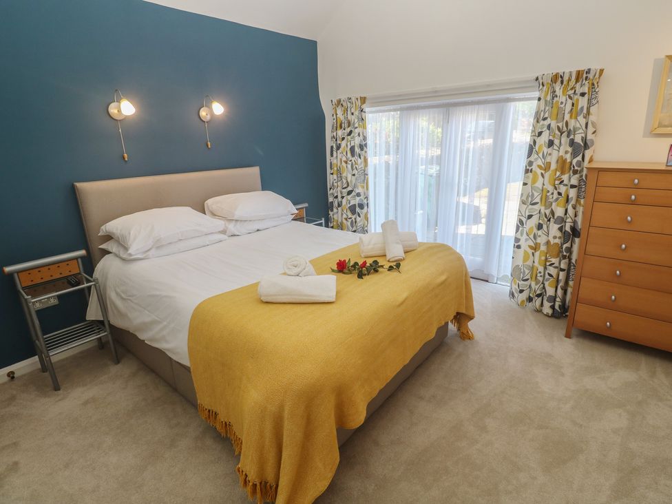 A bedroom with a bed and curtains at Meadowside Mousehole